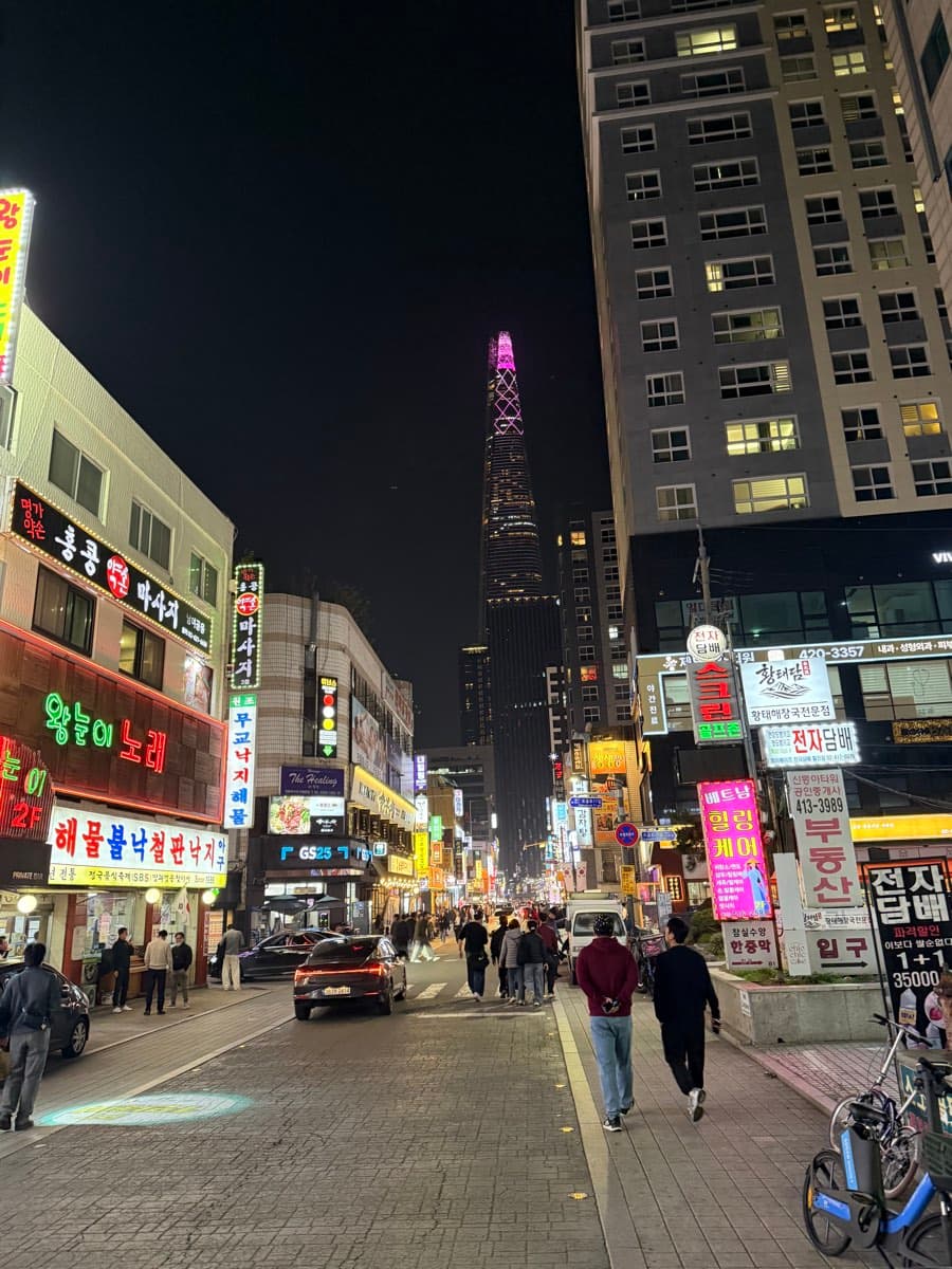 Rue commerçante de nuit à Jamsil, la Lotte World Tower au fond