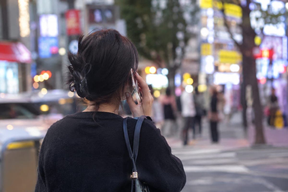 Appel téléphonique dans une rue animée de Séoul, le soir